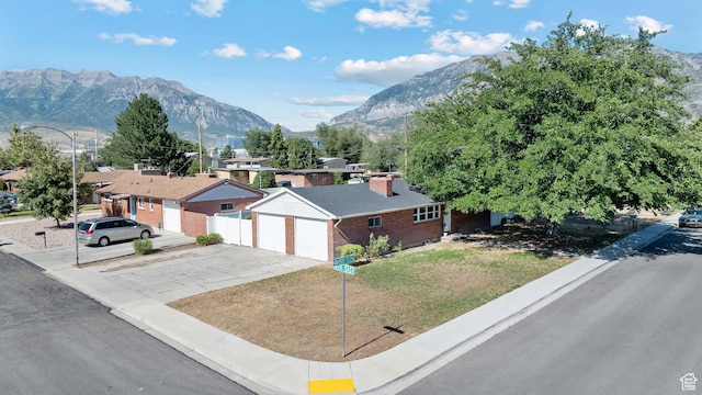 251 E 1500 S, Orem, UT 84058 - view of front of home featuring a mountain view, a detached garage, brick siding, a chimney, and driveway