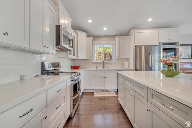10768 N Fiddlesticks Lot 30, Cedar Hills, UT 84062 - kitchen featuring appliances with stainless steel finishes, dark wood-style floors, light countertops, decorative backsplash, and white cabinets
