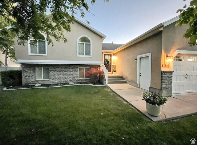 1184 Bridgecreek Ln, Layton, UT 84041 - view of front of home with stucco siding, a front yard, and a garage