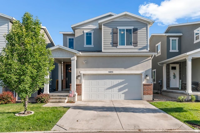 5631 W Still Well Ln S, Herriman, UT 84096 - view of front of property featuring a garage, a front yard, concrete driveway, brick siding, and stucco siding
