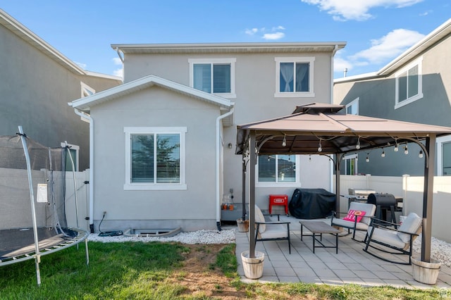 5631 W Still Well Ln S, Herriman, UT 84096 - rear view of house with a gazebo, a trampoline, a patio, stucco siding, and a fenced backyard