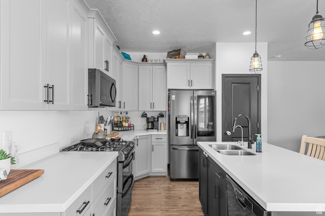 5631 W Still Well Ln S, Herriman, UT 84096 - kitchen featuring black appliances, light countertops, an island with sink, recessed lighting, and wood finished floors