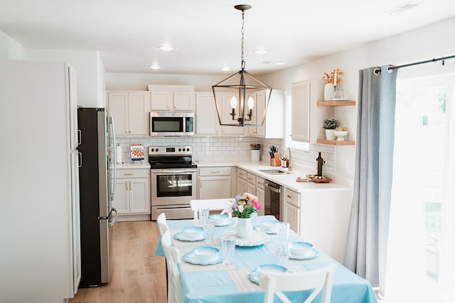 279 S 950 W, Spanish Fork, UT 84660 - kitchen with stainless steel appliances, a chandelier, decorative backsplash, light wood finished floors, and open shelves