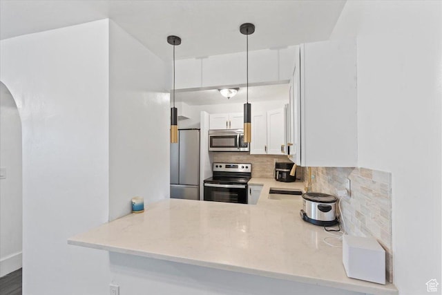 96 S 1000 W, Orem, UT 84058 - kitchen with appliances with stainless steel finishes, arched walkways, decorative backsplash, white cabinets, and pendant lighting