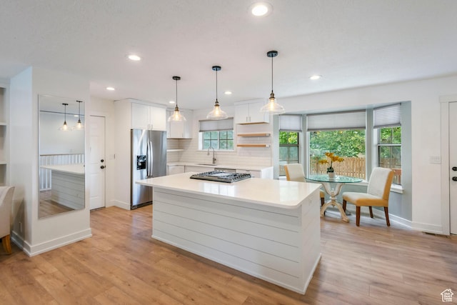 249 N 800 W, Orem, UT 84057 - kitchen featuring appliances with stainless steel finishes, light countertops, white cabinetry, decorative backsplash, and a kitchen island