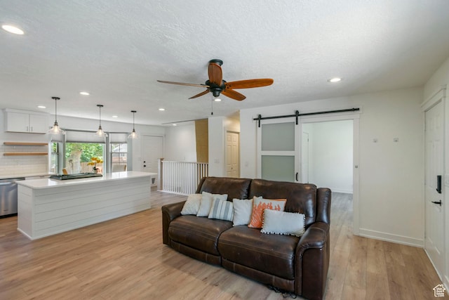 249 N 800 W, Orem, UT 84057 - living room featuring a barn door, ceiling fan, light wood-style flooring, recessed lighting, and a textured ceiling