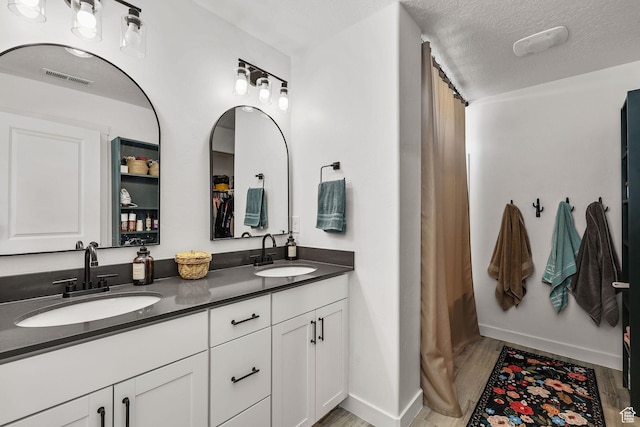 1098 S 4050 W, Syracuse, UT 84075 - bathroom with double vanity, wood finished floors, a textured ceiling, and a shower with curtain