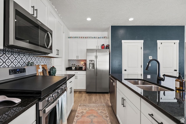 1098 S 4050 W, Syracuse, UT 84075 - kitchen featuring stainless steel appliances, white cabinetry, a textured ceiling, decorative backsplash, and light wood-style floors