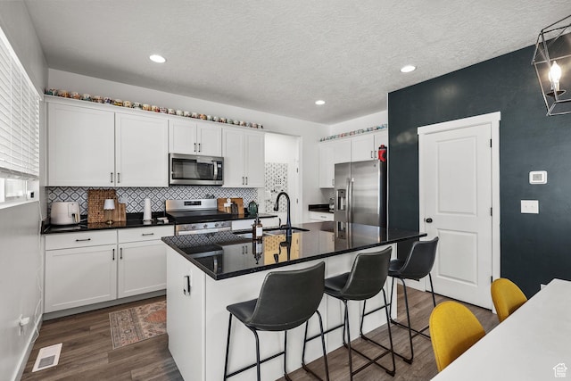 1098 S 4050 W, Syracuse, UT 84075 - kitchen with stainless steel appliances, dark wood-style flooring, white cabinetry, decorative backsplash, and recessed lighting