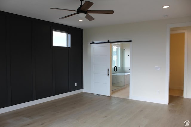 1318 S 1090 E, Salem, UT 84653 - unfurnished bedroom featuring a barn door, light wood finished floors, recessed lighting, ceiling fan, and ensuite bathroom