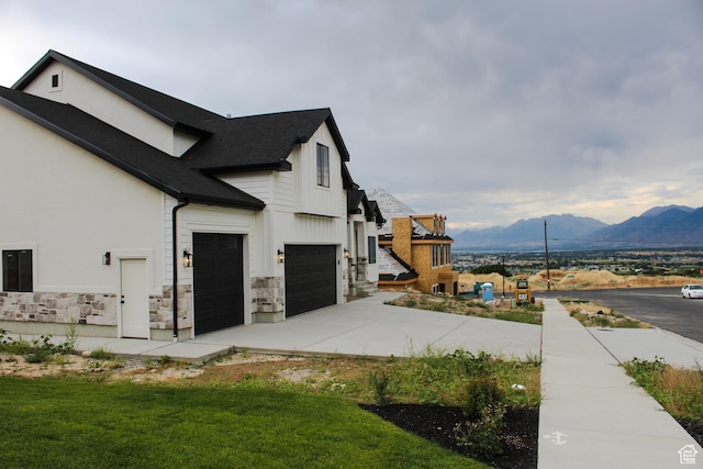 1318 S 1090 E, Salem, UT 84653 - view of property exterior with a mountain view, concrete driveway, stone siding, a garage, and roof with shingles