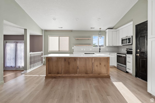 616 S 1430 W, Lehi, UT 84043 - kitchen featuring stainless steel appliances, vaulted ceiling, a kitchen island, light countertops, and white cabinetry