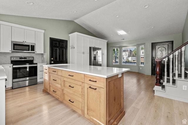 616 S 1430 W, Lehi, UT 84043 - kitchen featuring appliances with stainless steel finishes, vaulted ceiling, light wood finished floors, light countertops, and tasteful backsplash