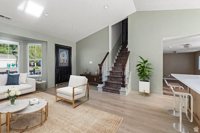 616 S 1430 W, Lehi, UT 84043 - living area featuring lofted ceiling, stairs, light wood-style flooring, and a textured ceiling
