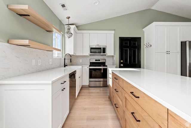 616 S 1430 W, Lehi, UT 84043 - kitchen featuring appliances with stainless steel finishes, vaulted ceiling, light wood-style floors, backsplash, and hanging light fixtures