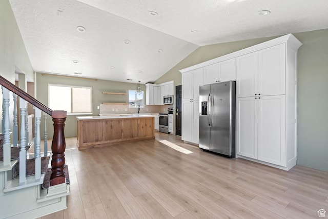 616 S 1430 W, Lehi, UT 84043 - kitchen featuring appliances with stainless steel finishes, light wood finished floors, light countertops, vaulted ceiling, and white cabinets