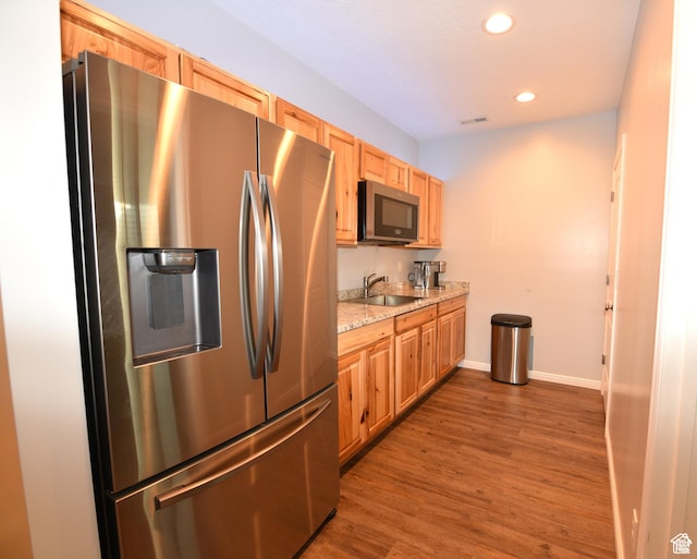 4666 W Olympic Wood Ct, West Jordan, UT 84084 - kitchen with stainless steel appliances, wood finished floors, recessed lighting, light brown cabinets, and light stone countertops