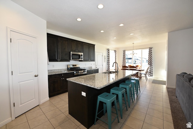 4666 W Olympic Wood Ct, West Jordan, UT 84084 - kitchen with appliances with stainless steel finishes, light tile patterned flooring, a kitchen breakfast bar, recessed lighting, and light stone counters
