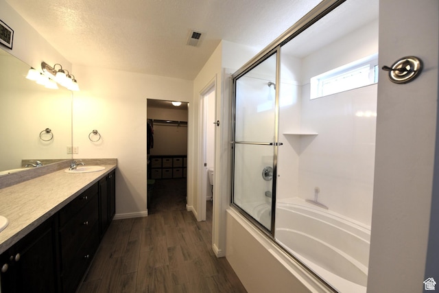 4666 W Olympic Wood Ct, West Jordan, UT 84084 - full bath featuring double vanity, wood finished floors, a walk in closet, enclosed tub / shower combo, and a textured ceiling