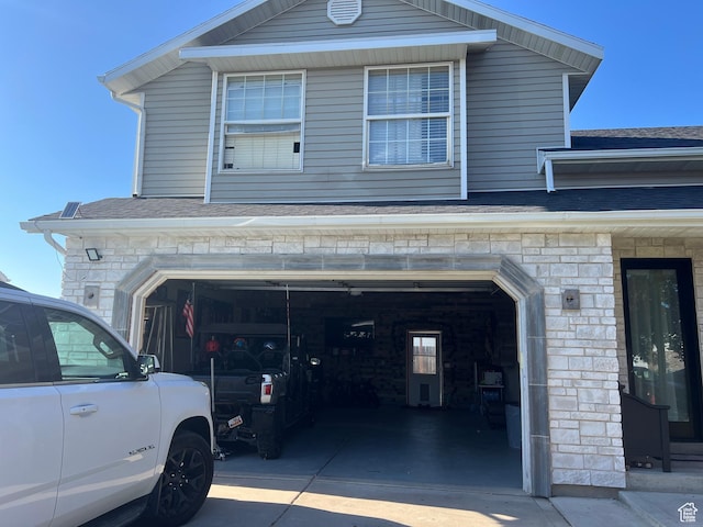 4106 W 4875 S, Roy, UT 84067 - view of home's exterior with driveway, stone siding, a shingled roof, and an attached garage