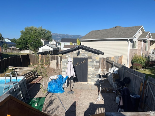 4106 W 4875 S, Roy, UT 84067 - rear view of house with a fenced backyard, a storage shed, and a mountain view