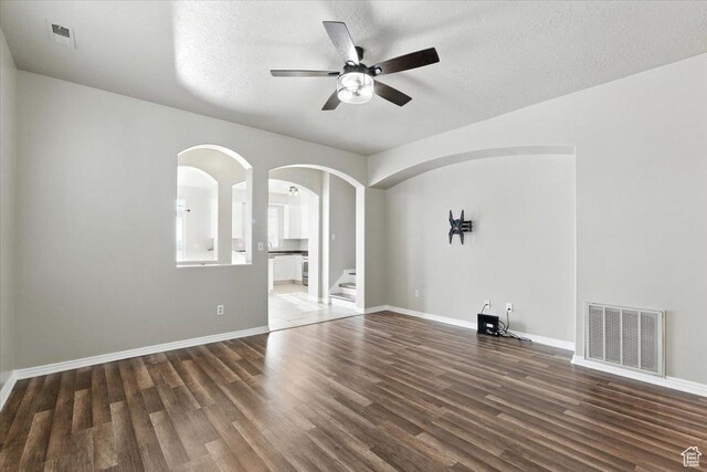 729 N Buckingham Dr W, North Salt Lake, UT 84054 - unfurnished living room featuring ceiling fan, wood finished floors, arched walkways, and a textured ceiling