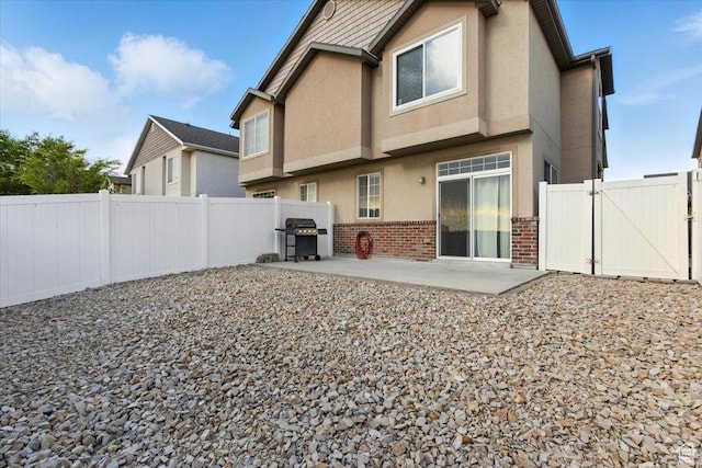 729 N Buckingham Dr W, North Salt Lake, UT 84054 - rear view of property with a patio, brick siding, stucco siding, a gate, and a fenced backyard