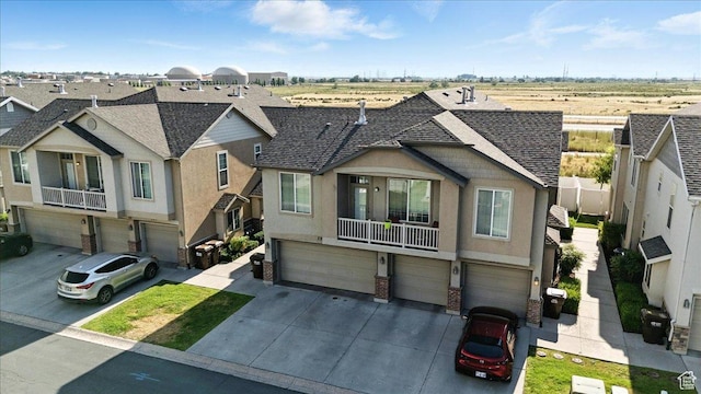 729 N Buckingham Dr W, North Salt Lake, UT 84054 - view of front facade featuring an attached garage, stucco siding, driveway, roof with shingles, and a residential view