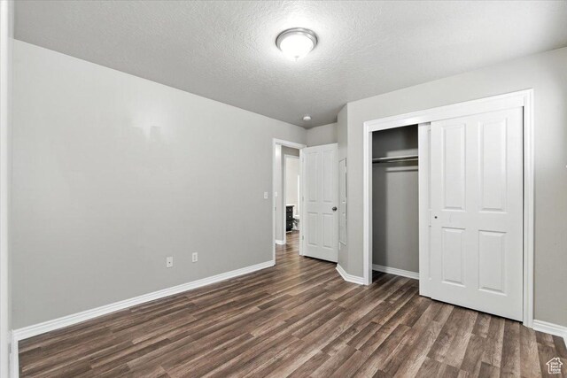 729 N Buckingham Dr W, North Salt Lake, UT 84054 - unfurnished bedroom featuring dark wood-style flooring, a closet, and a textured ceiling