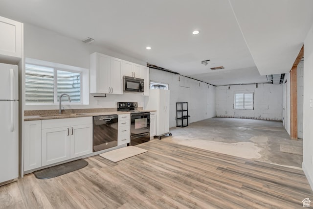 9517 N Shiloh Way E, Eagle Mountain, UT 84005 - kitchen with black appliances, white cabinets, light wood-style flooring, light stone counters, and recessed lighting