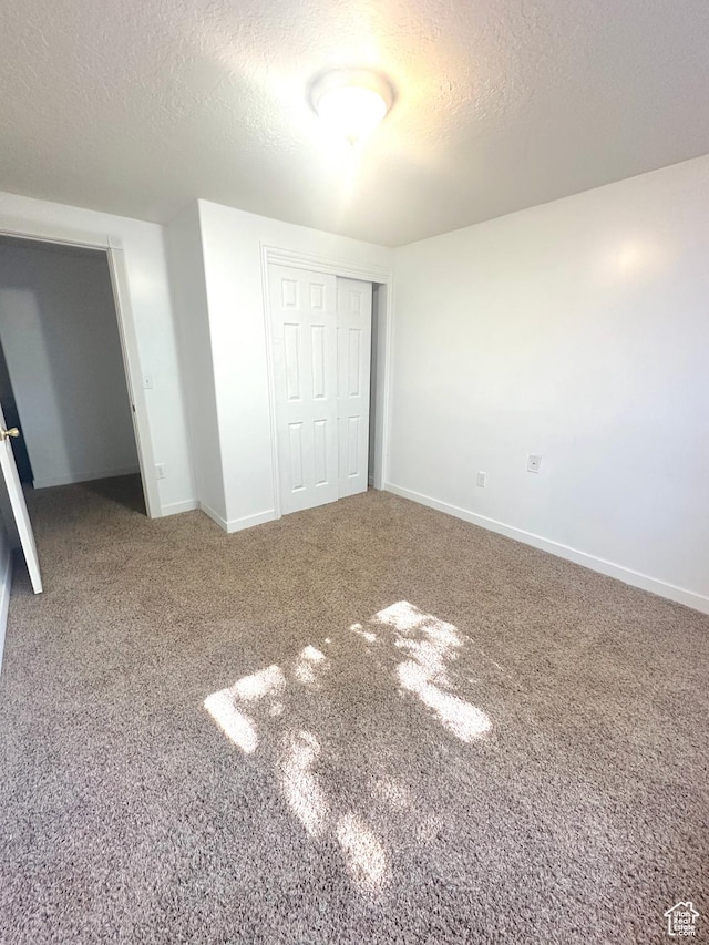 2592 W 2650 N, Clinton, UT 84015 - unfurnished bedroom featuring a textured ceiling, a closet, and carpet floors