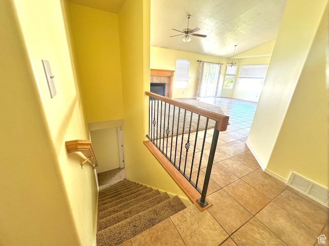 2592 W 2650 N, Clinton, UT 84015 - stairway with lofted ceiling, tile patterned floors, a ceiling fan, a fireplace, and a textured ceiling