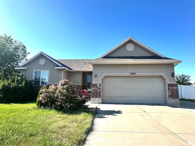 2592 W 2650 N, Clinton, UT 84015 - ranch-style house featuring stucco siding, a garage, driveway, and brick siding