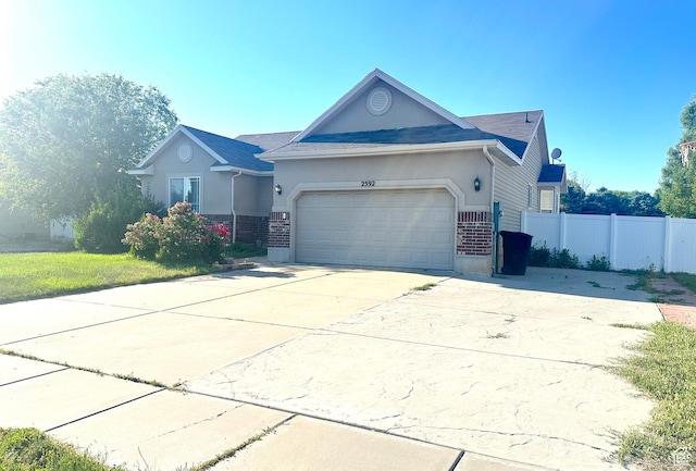 2592 W 2650 N, Clinton, UT 84015 - single story home featuring an attached garage, concrete driveway, brick siding, and stucco siding