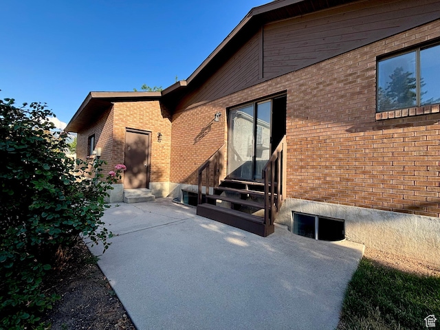 7692 S Chad St, Midvale, UT 84047 - view of property exterior featuring entry steps, brick siding, and a patio area