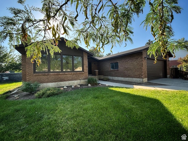 7692 S Chad St, Midvale, UT 84047 - view of front facade with brick siding, concrete driveway, a front yard, and a garage