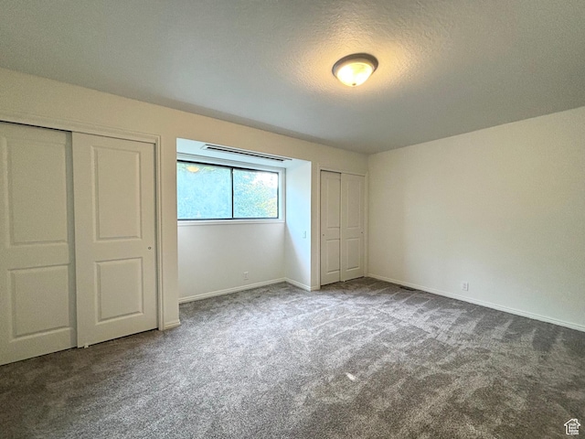 7692 S Chad St, Midvale, UT 84047 - unfurnished bedroom featuring carpet floors, a textured ceiling, and two closets