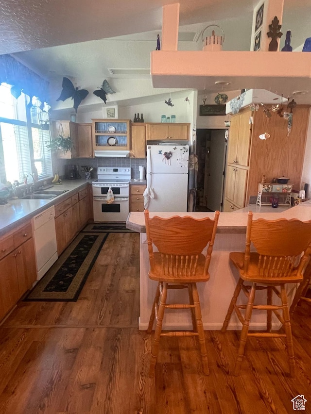 5518 E 500 N, Fort Duchesne, UT 84026 - kitchen with white appliances, dark wood-style floors, a peninsula, a kitchen bar, and backsplash