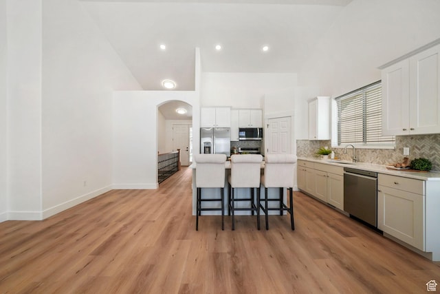 749 E 1600 S, Orem, UT 84097 - kitchen featuring stainless steel appliances, a kitchen breakfast bar, arched walkways, tasteful backsplash, and a towering ceiling