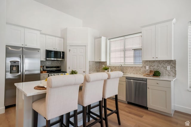 749 E 1600 S, Orem, UT 84097 - kitchen featuring stainless steel appliances, a kitchen island, a breakfast bar area, light countertops, and light wood-style flooring