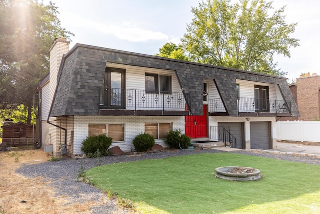 8268 S 865 E, Sandy, UT 84094 - view of property featuring a balcony, brick siding, an attached garage, mansard roof, and an outdoor fire pit