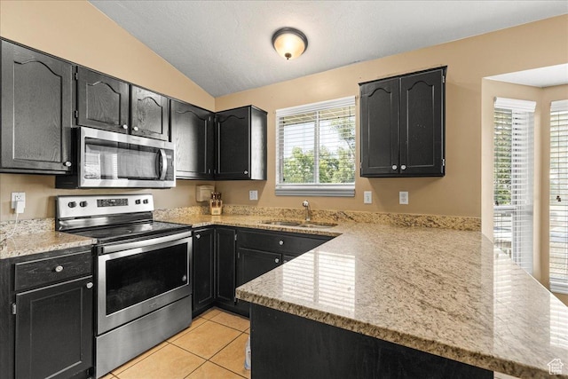 6410 W Martin Way S, West Valley City, UT 84128 - kitchen with stainless steel appliances, a peninsula, vaulted ceiling, and dark cabinetry