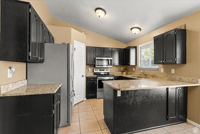 6410 W Martin Way S, West Valley City, UT 84128 - kitchen featuring stainless steel appliances, a peninsula, vaulted ceiling, dark cabinetry, and light tile patterned flooring