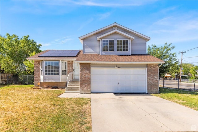 6410 W Martin Way S, West Valley City, UT 84128 - view of front of home with roof mounted solar panels, driveway, a garage, and brick siding