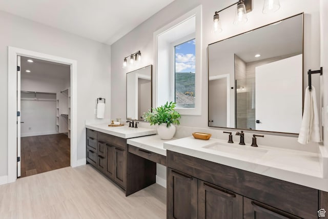 11811 N Apex Way Unit 66, Hideout, UT 84036 - full bathroom with double vanity, a walk in closet, a tile shower, wood finished floors, and recessed lighting