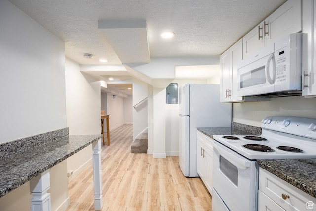 10257 S 1280 E, Sandy, UT 84094 - kitchen featuring white appliances, light wood finished floors, a textured ceiling, white cabinets, and dark stone countertops