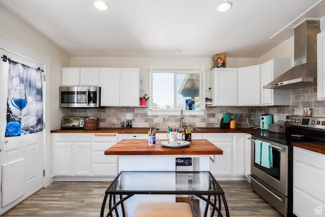10257 S 1280 E, Sandy, UT 84094 - kitchen with stainless steel appliances, wall chimney exhaust hood, wooden counters, wood finished floors, and recessed lighting