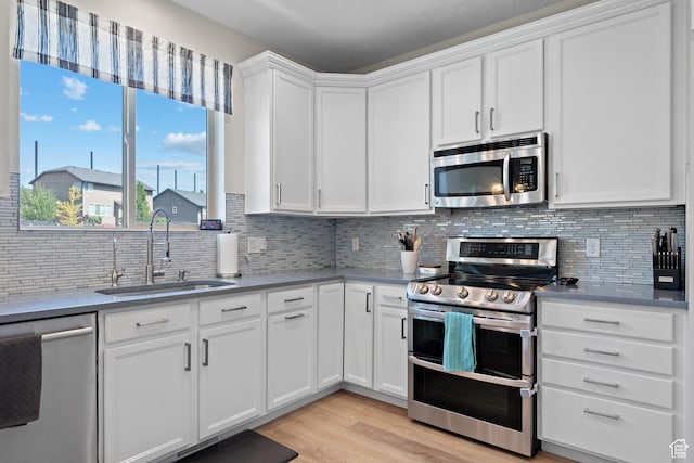8791 N Suffolk Ln, Eagle Mountain, UT 84005 - kitchen featuring appliances with stainless steel finishes, light wood finished floors, white cabinets, backsplash, and light countertops
