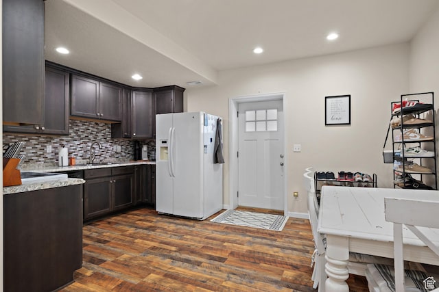 8791 N Suffolk Ln, Eagle Mountain, UT 84005 - kitchen with white fridge with ice dispenser, dark brown cabinets, decorative backsplash, dark wood-type flooring, and recessed lighting