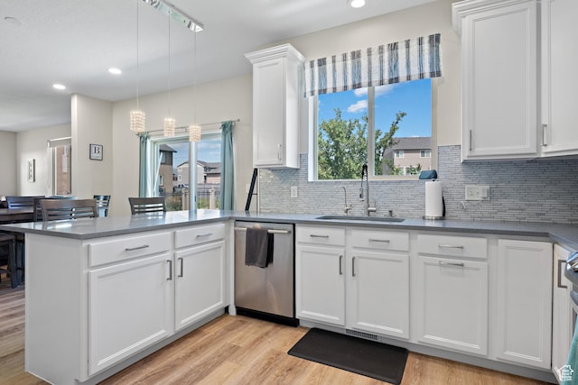 8791 N Suffolk Ln, Eagle Mountain, UT 84005 - kitchen with stainless steel dishwasher, a peninsula, decorative backsplash, white cabinets, and light wood-style flooring